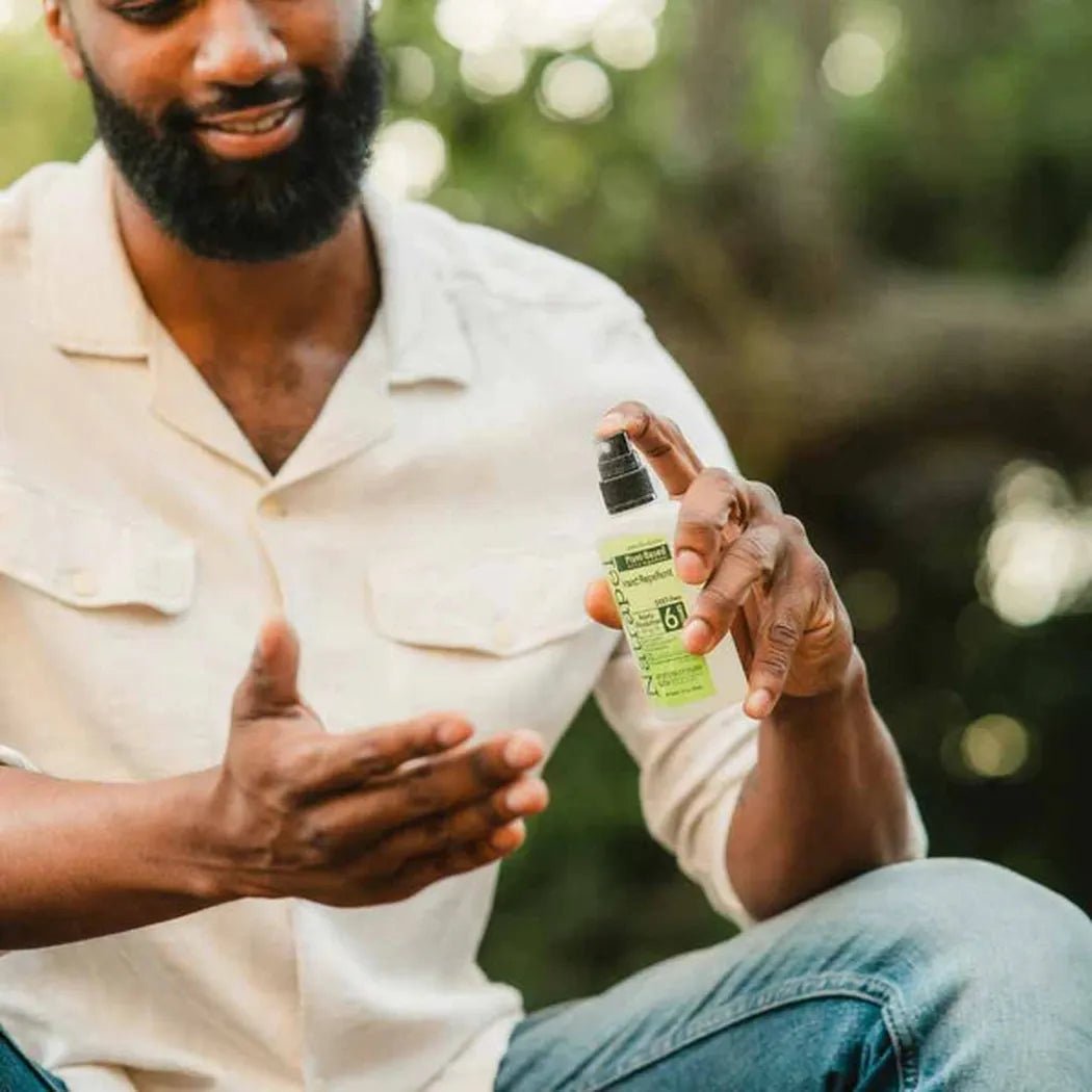 A man in a white shirt holds the Adventure Ready Brands Natrapel Lemon Eucalyptus Pump 3.4oz bottle in an outdoor setting.