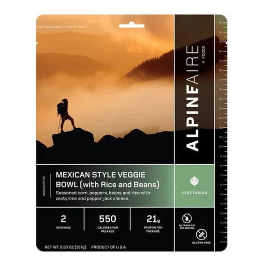 Backpacker silhouette on a mountain against a sunset sky on the AlpineAire Mexican Style Veggie Bowl package.