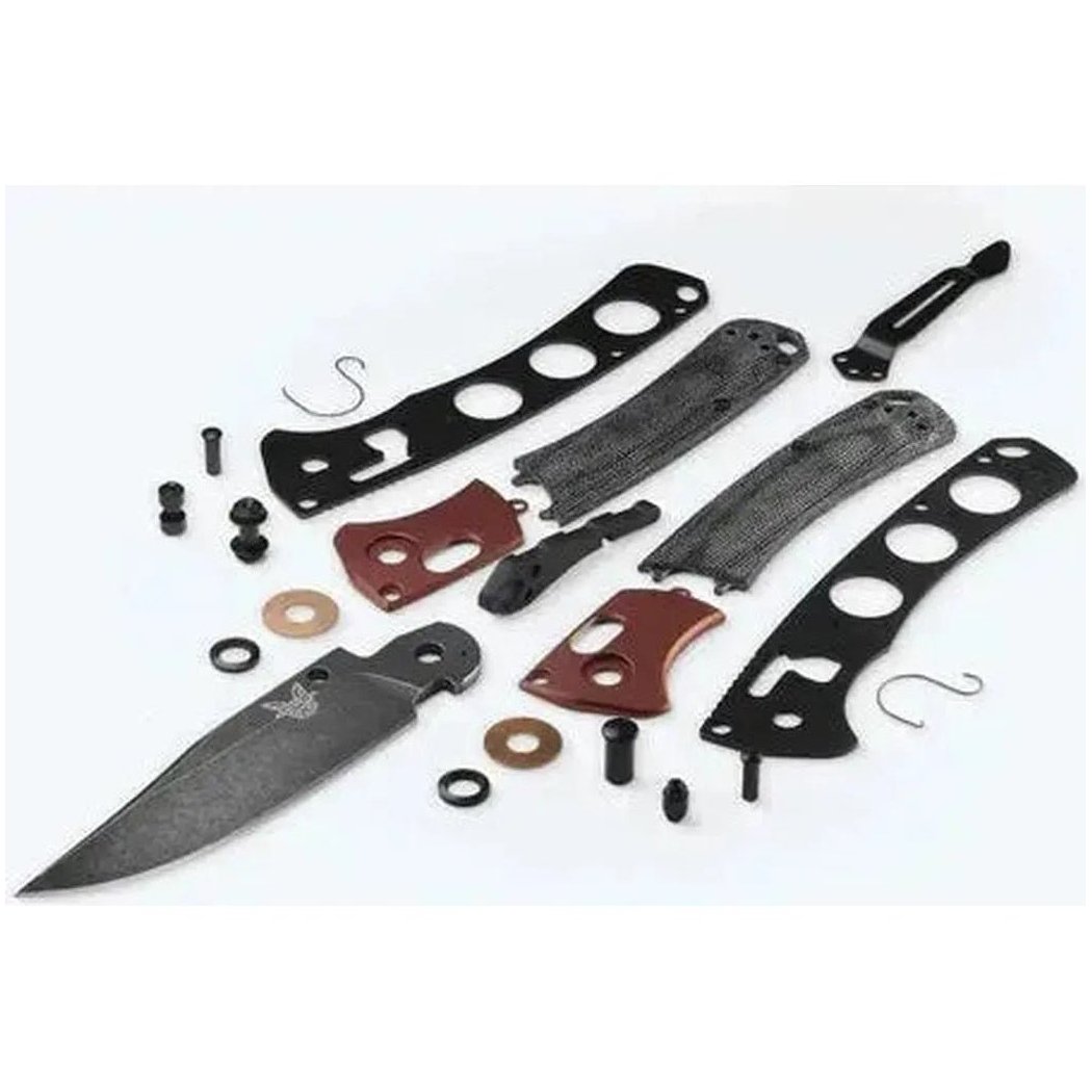 A top-down view of the Benchmade Mini Crooked River knife kit with black and red components on a white background.