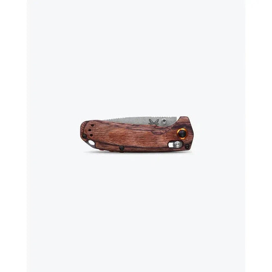 A side view of the Benchmade North Fork in Maple Stabilized Wood with a serrated blade and a wooden handle against a white background.