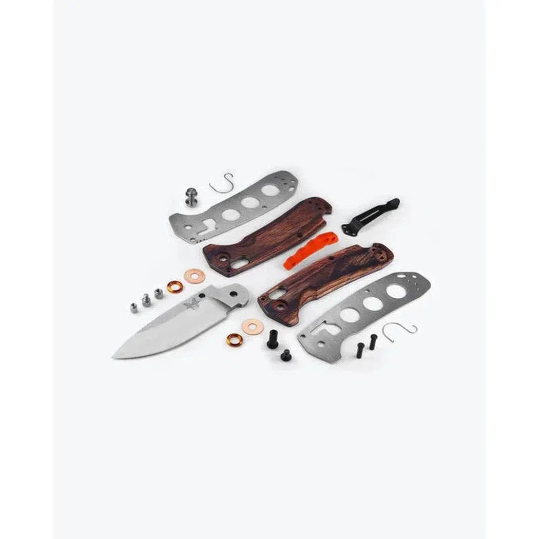 A disassembled Benchmade North Fork knife with maple stabilized wood handles and a white blade laid out on a white background.
