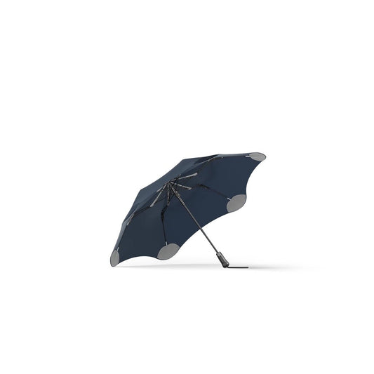 Side view of the Blunt Metro Black umbrella showing its curved canopy and silver accents against a white background.