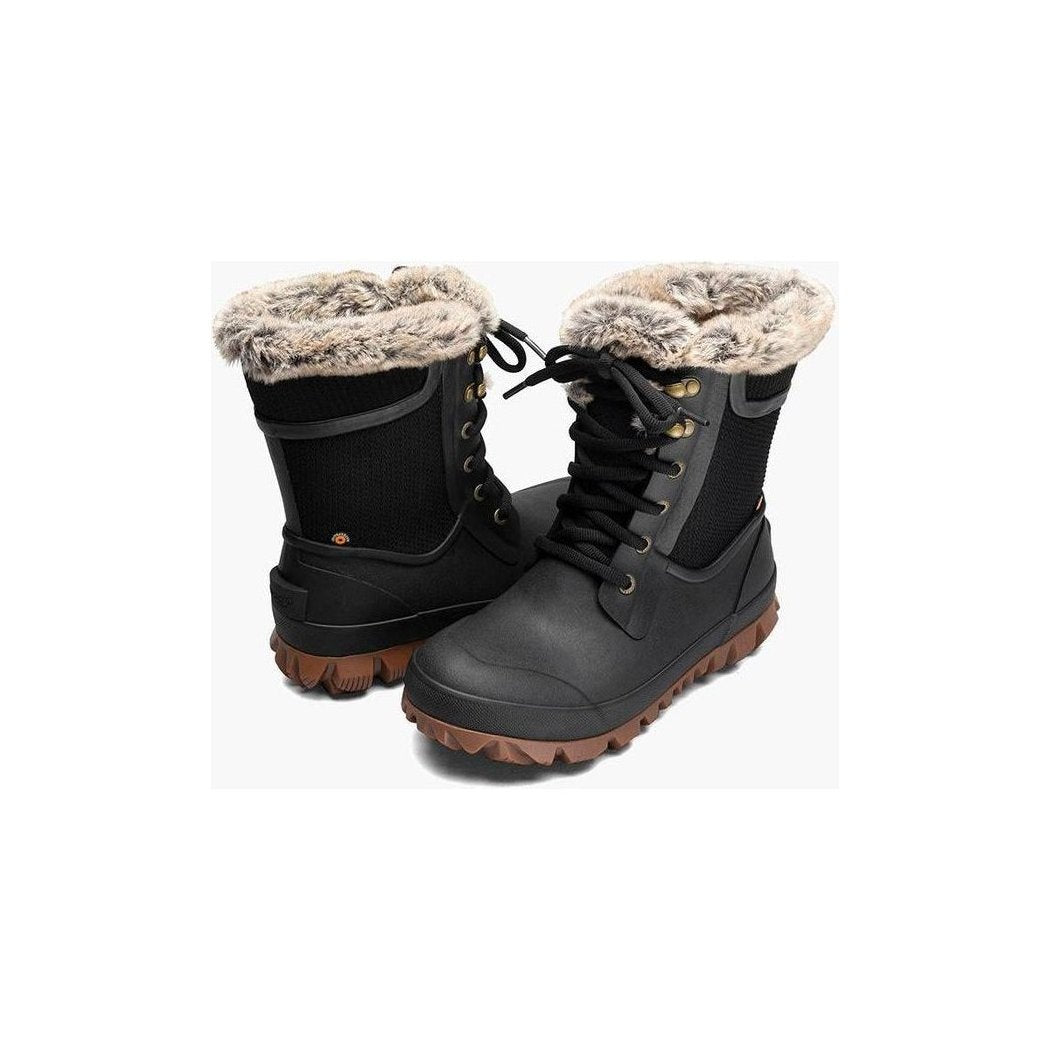 Side view of the Bogs Footwear Women's Arcata Trek Dots in Black showing the fur-lined collar and brown outsole against a white background.