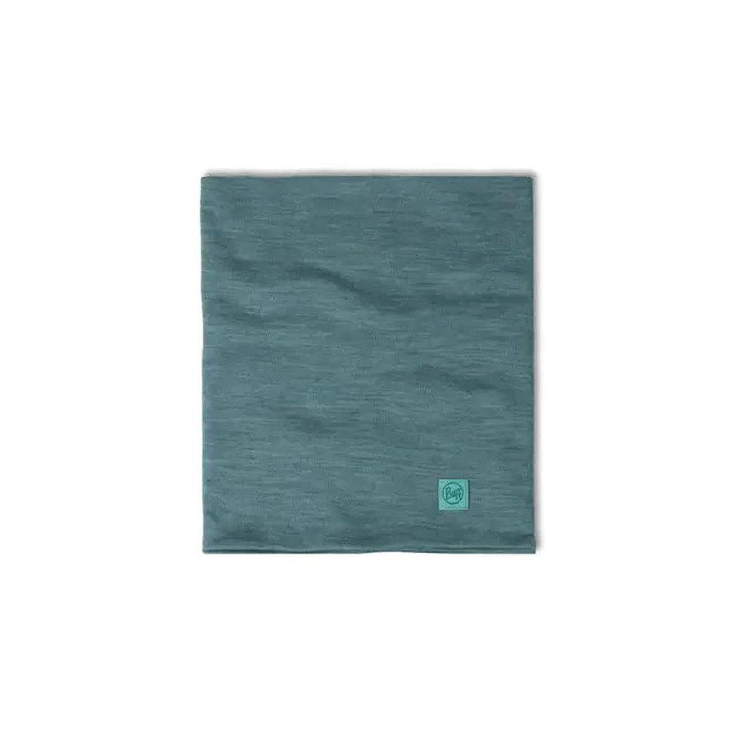 A flat lay of the Indigo Buff Merino Heavyweight Neck Warmer Solid Colors with a small logo tag visible.