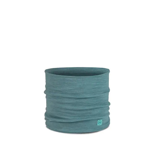 A front view of the Buff Merino Heavyweight Neck Warmer Solid Colors in Indigo with a small logo tag on the bottom right, against a plain white background.