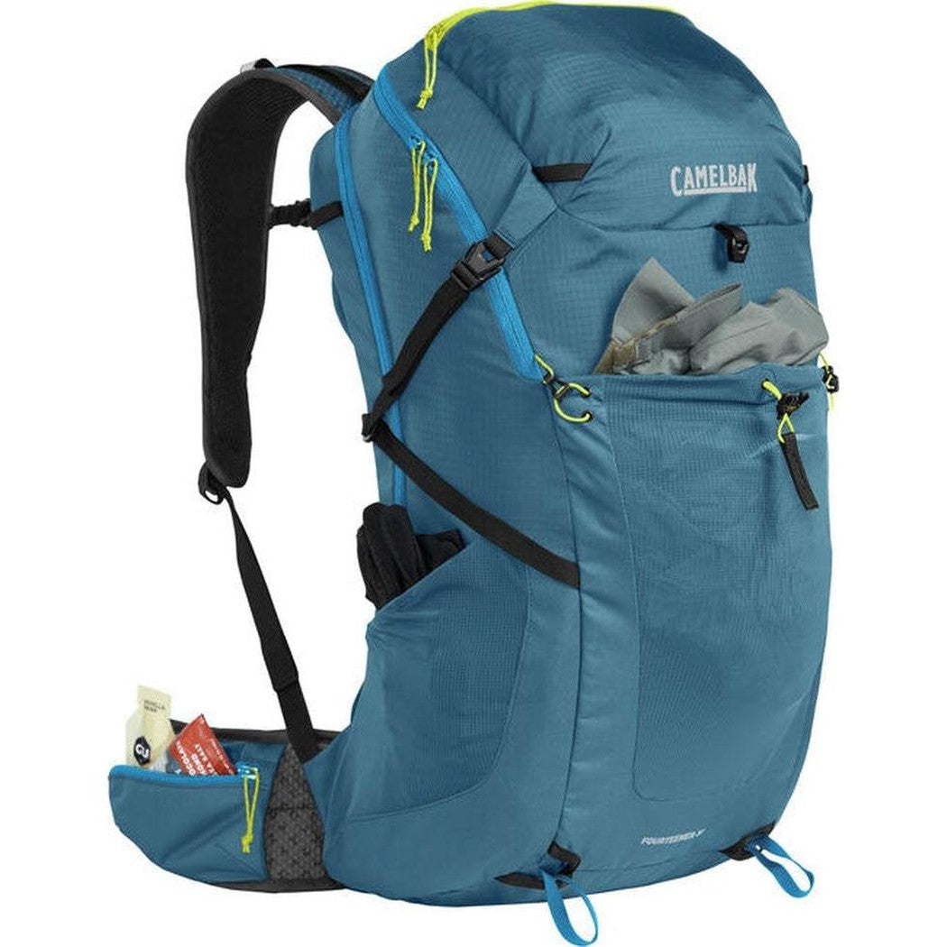 A side view of the CamelBak Fourteener 32 in Gibraltar Navy/Summer Lime showing the front pocket with gloves and a white background.