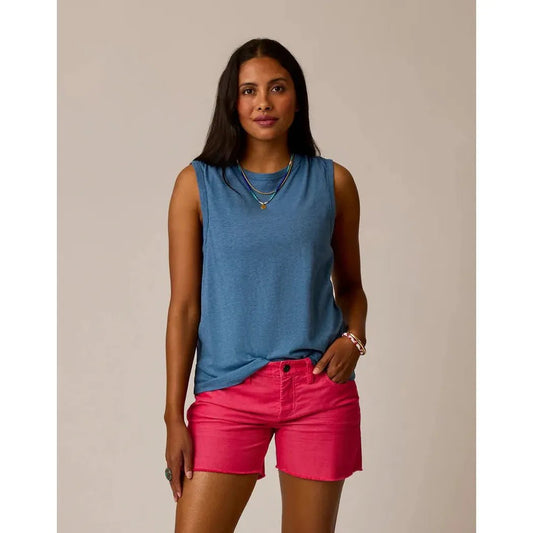 A woman wearing the Carve Designs Women's Larisa Hemp Tank in Captain blue and pink shorts stands against a neutral background.