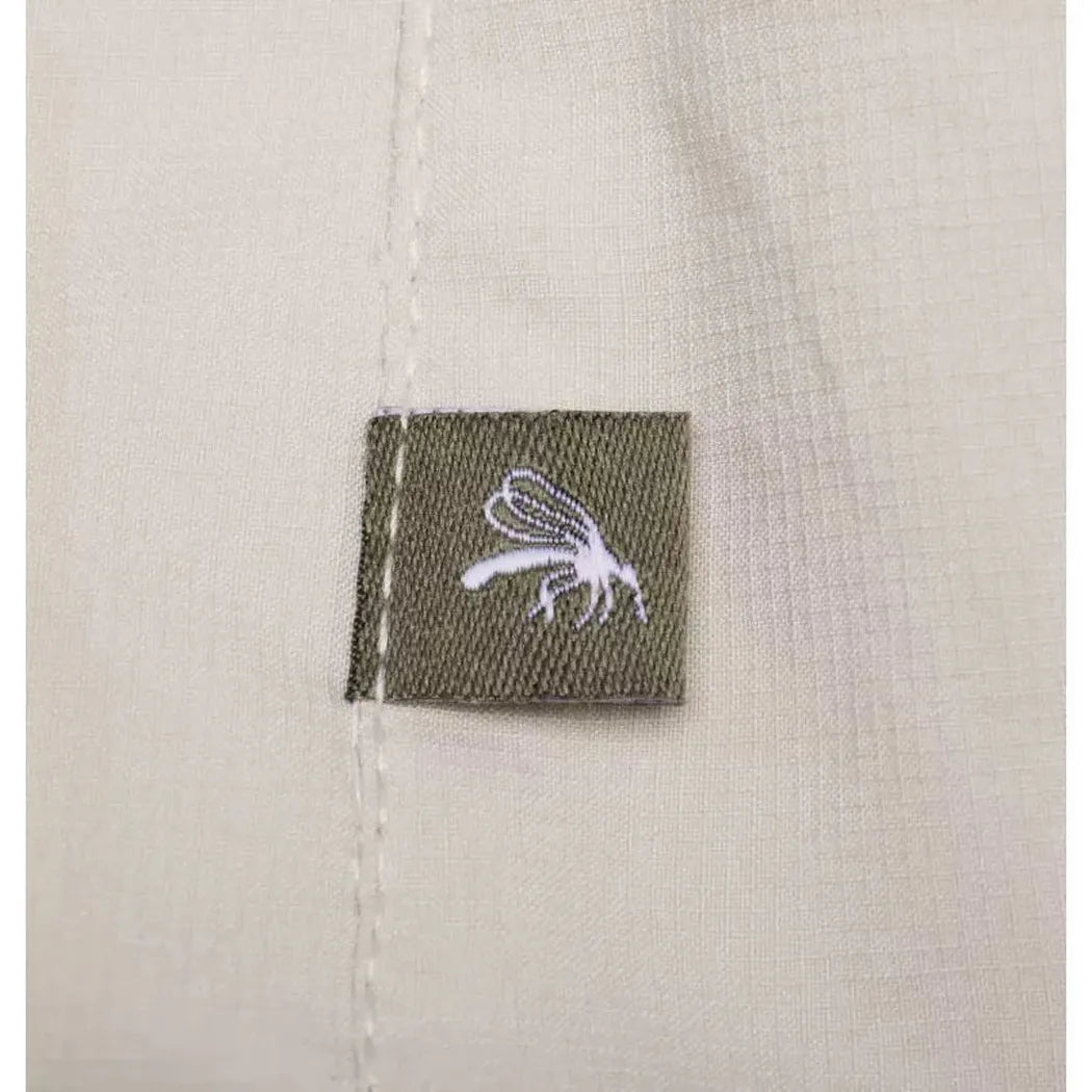 A close-up of the Columbia Sportswear Men's Skien Valley Hooded Long Sleeve Shirt in Dark Stone showing the brand tag against a light fabric background.