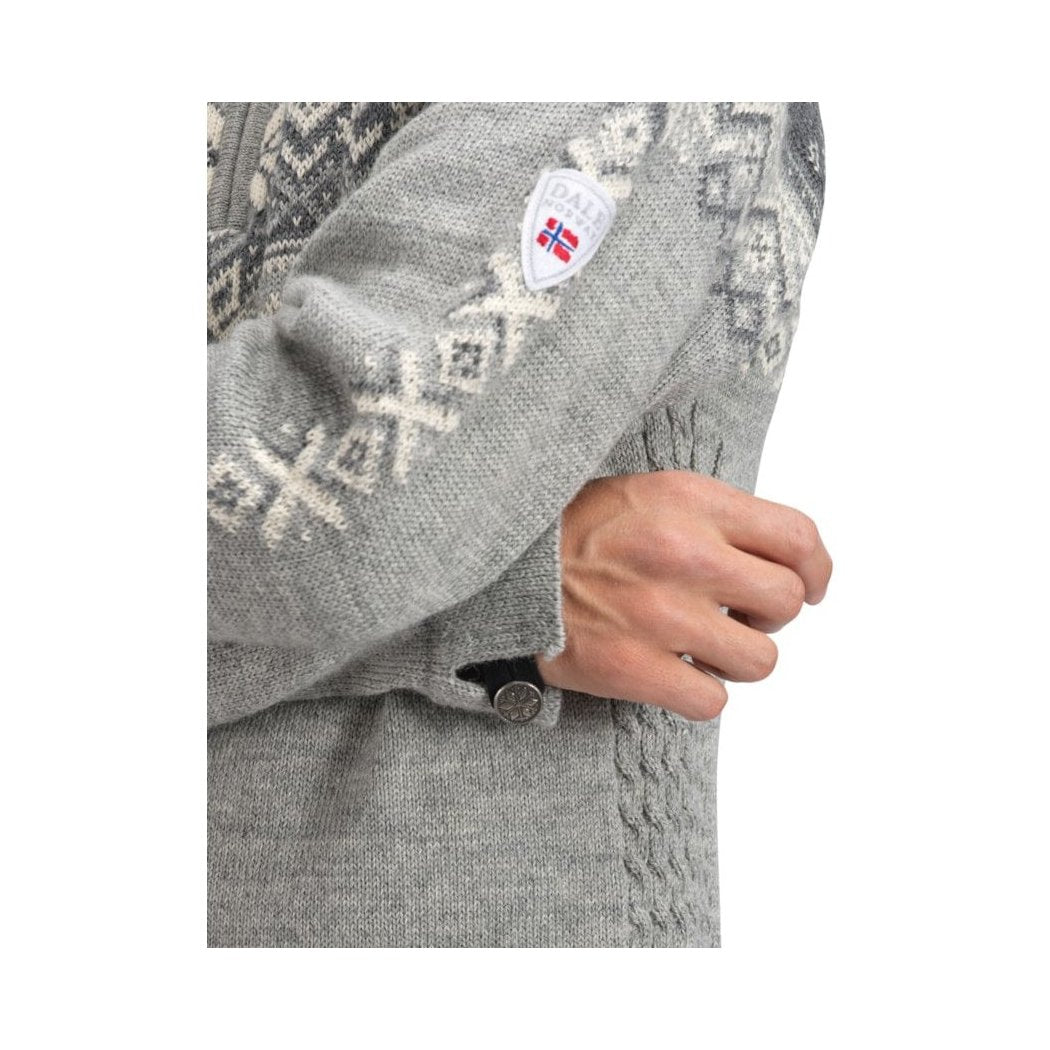 A close-up of the Dale Of Norway Men's 140th Anniversary Sweater-SAMPLE in E, showing the patterned sleeve and a hand adjusting the cuff.