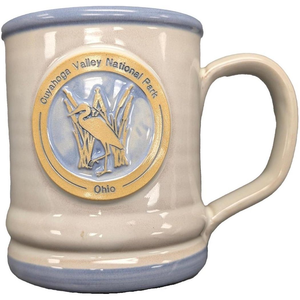 A side view of the Deneen Pottery Cuyahoga Valley National Park Mug showing the embossed heron logo against a white background.