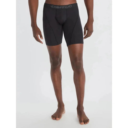 A front view of a Black/Black Exofficio Men's Give-N-Go Sport 2.0 Boxer Brief 9" on a barefoot model against a white background.