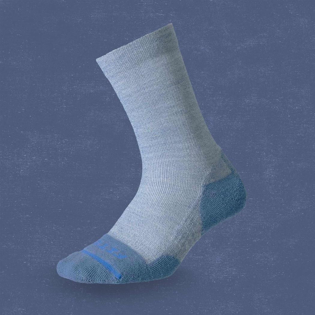 Side view of the FITS Light Cushion Crew in Ocean showing the blue toe and heel against a blue background.