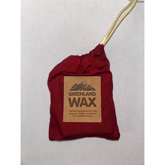 A blue Fjallraven Greenland Wax Bag hangs from a string against a white background.