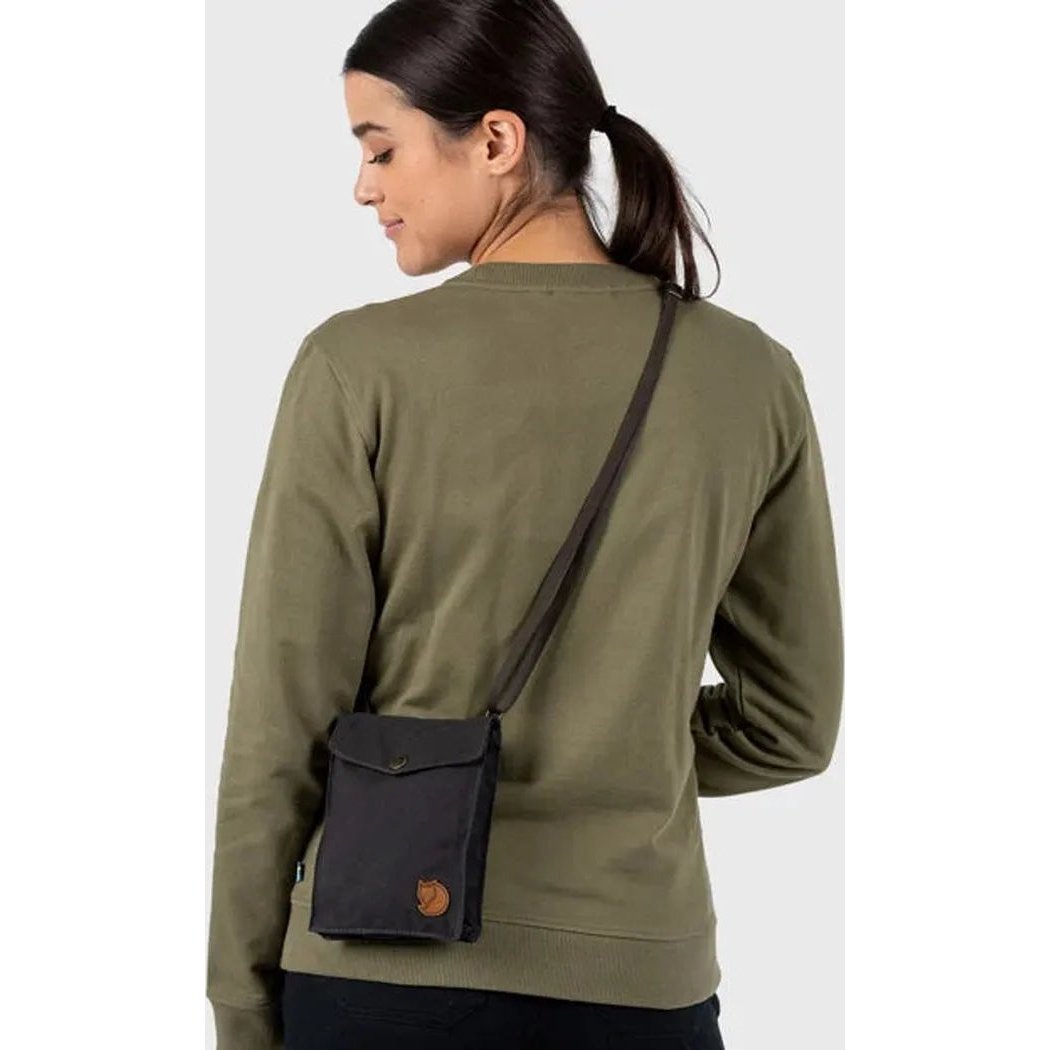 Back view of the Fjallraven Pocket in Black on a model wearing an olive sweatshirt against a plain background.