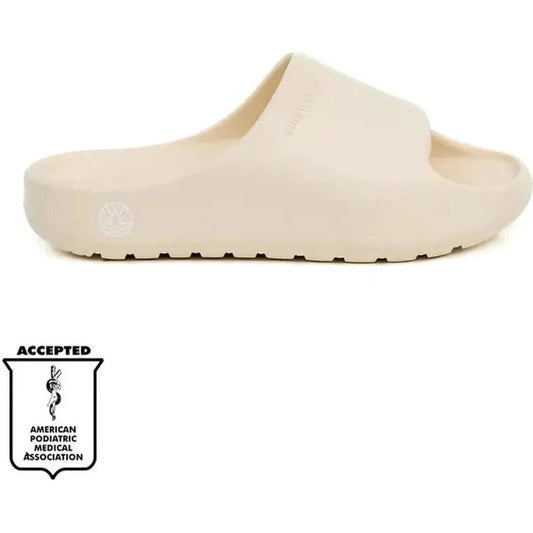Side view of the Freewaters Women's Cloud9 Slide in Bone showing the wide strap and the American Podiatric Medical Association logo at the bottom.