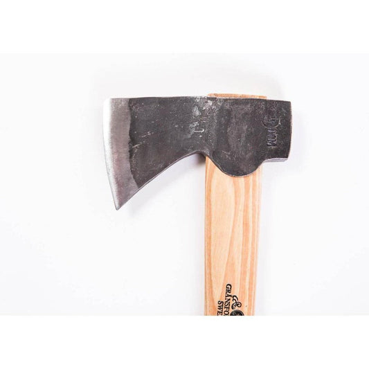 A close-up of the Gransfors Bruk Wildlife Hatchet with a light wooden handle and a dark, slightly worn blade against a plain white background.