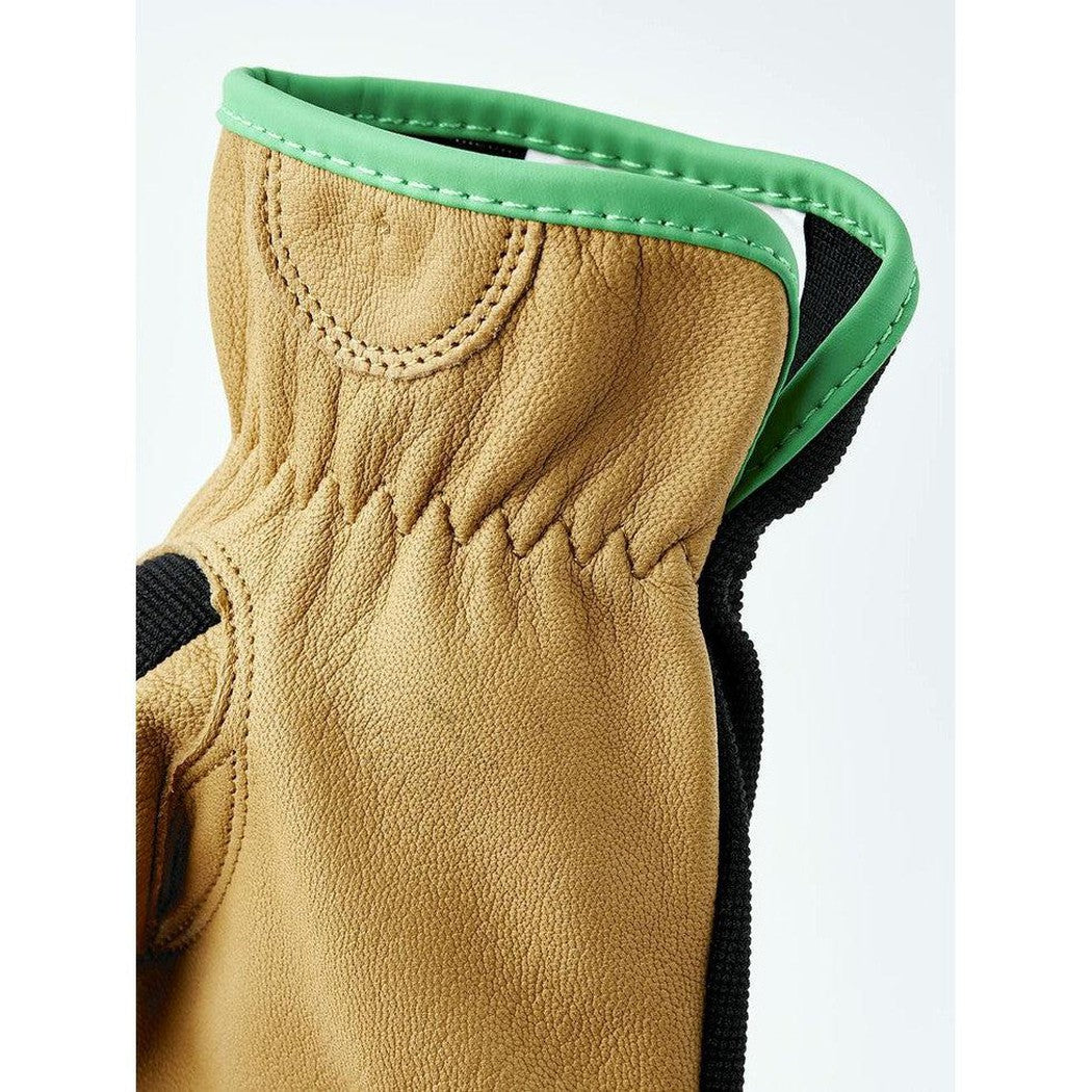 A close-up of the Hestra Job Golden Kobolt glove showing its tan leather and green trim against a white background.