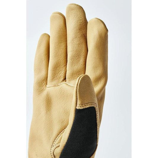 A close-up of the Hestra Job Golden Kobolt tan work glove showing the black padded palm and a plain white background.
