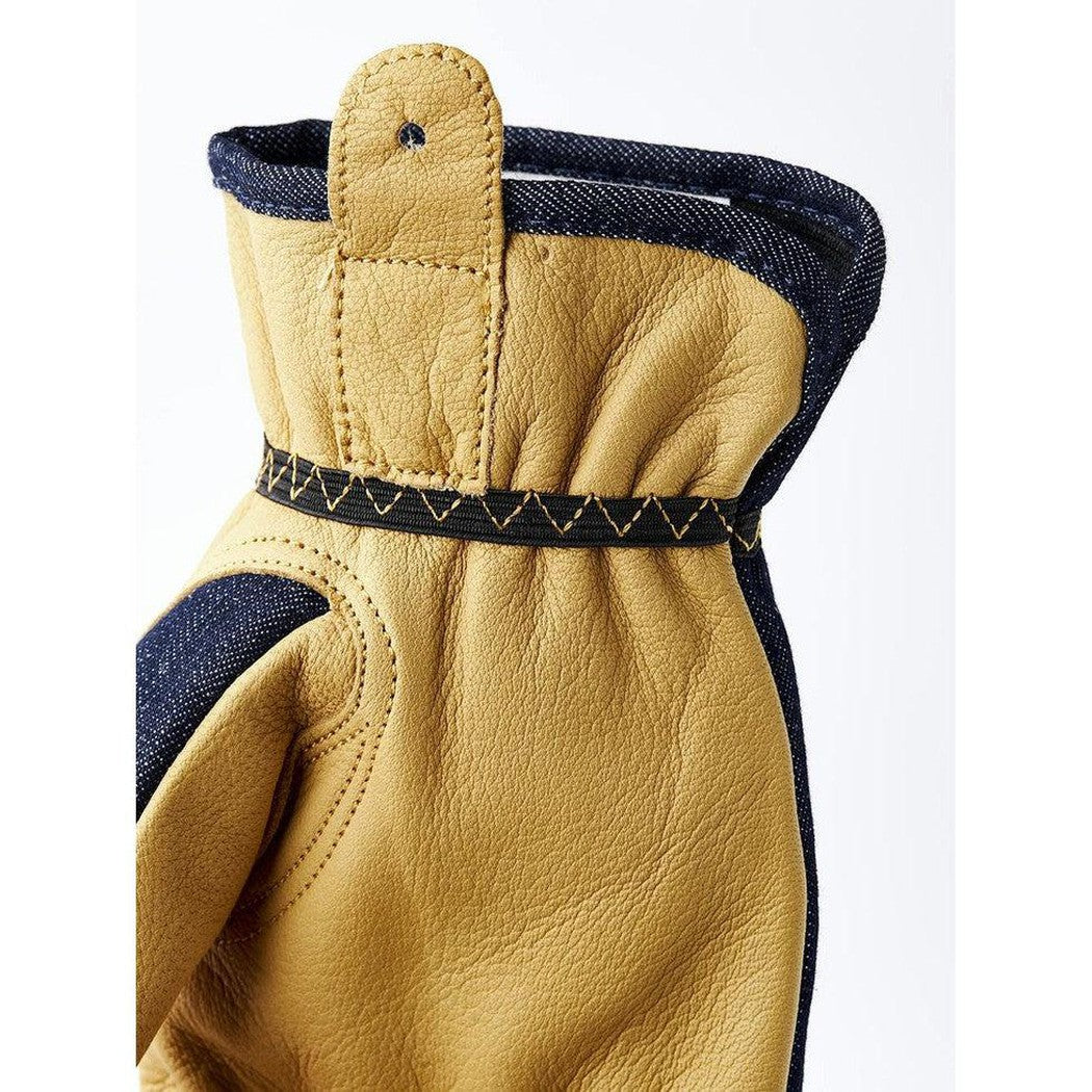 Side view of the Hestra Job Kobolt Denim work glove showing the indigo denim cuff and stitching against a white background.