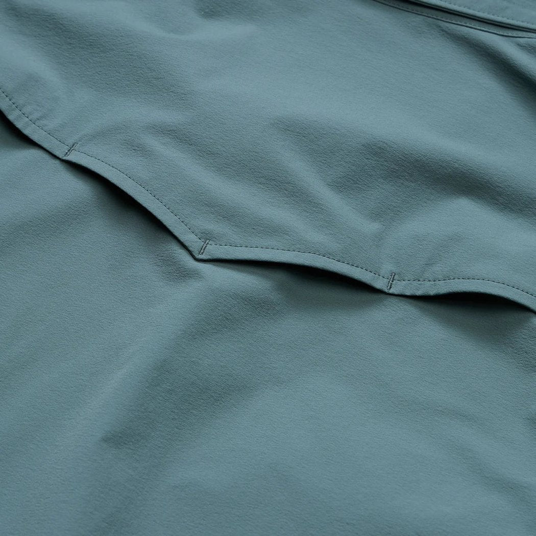 A close-up of the Howler Brothers Emerger Tech Longsleeve in Stormy Sea showing the stitching detail.