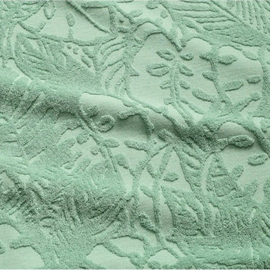 A close-up of the Howler Brothers Plusherman Terry Polo in Cream showing the textured, leaf-patterned fabric.