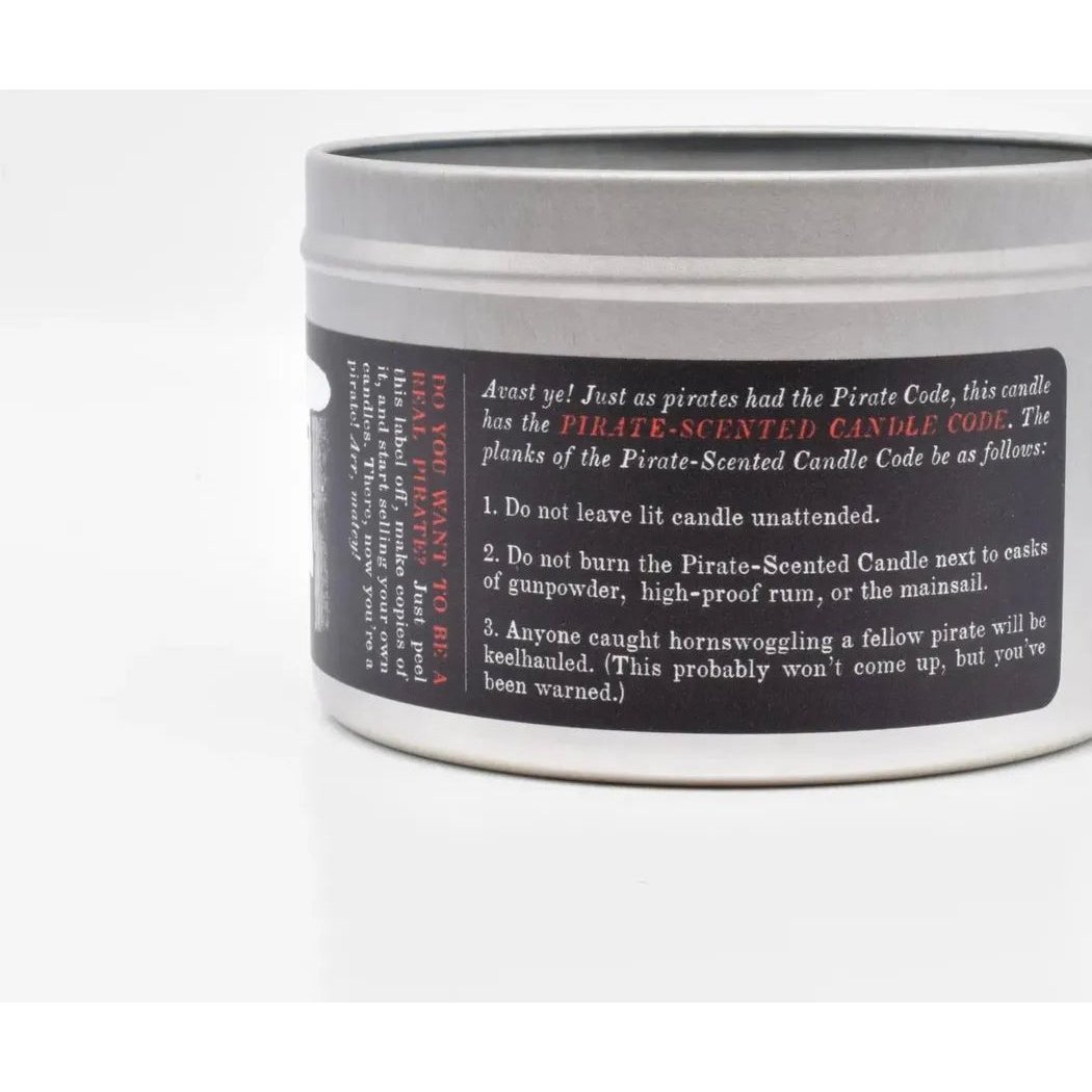 A close-up of the JD and Kate Industries Pirate Scented Candle in a silver tin with a black label showing the Pirate Code rules against a plain white background.