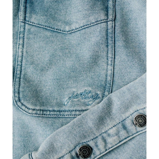 A close-up of the Jetty Women's Eden Knit Shirt in Denim showing the front pocket and button placket.