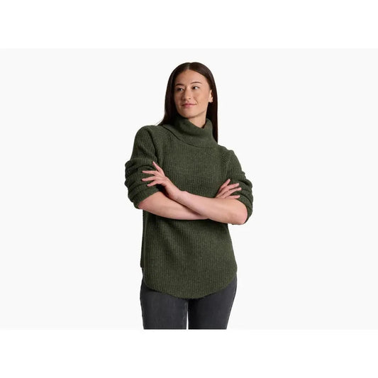 A model wearing the Kuhl Women's Sienna Sweater in Cherrywood stands with arms crossed against a plain white background.
