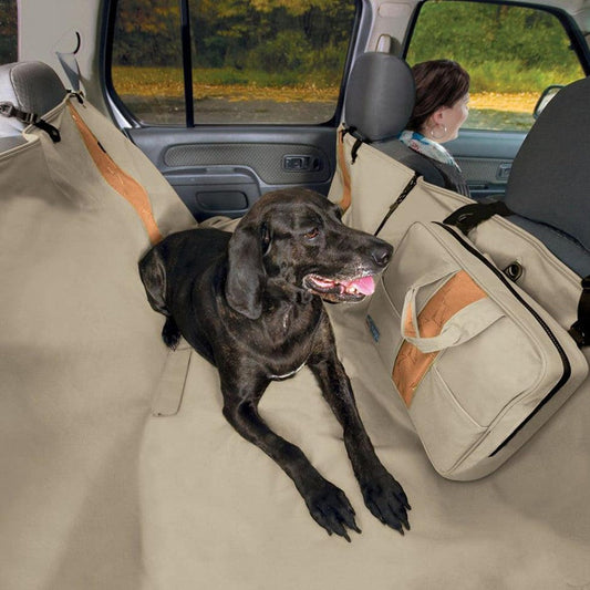 A charcoal Kurgo Wander Hammock in a car with a black dog and a woman in the background.