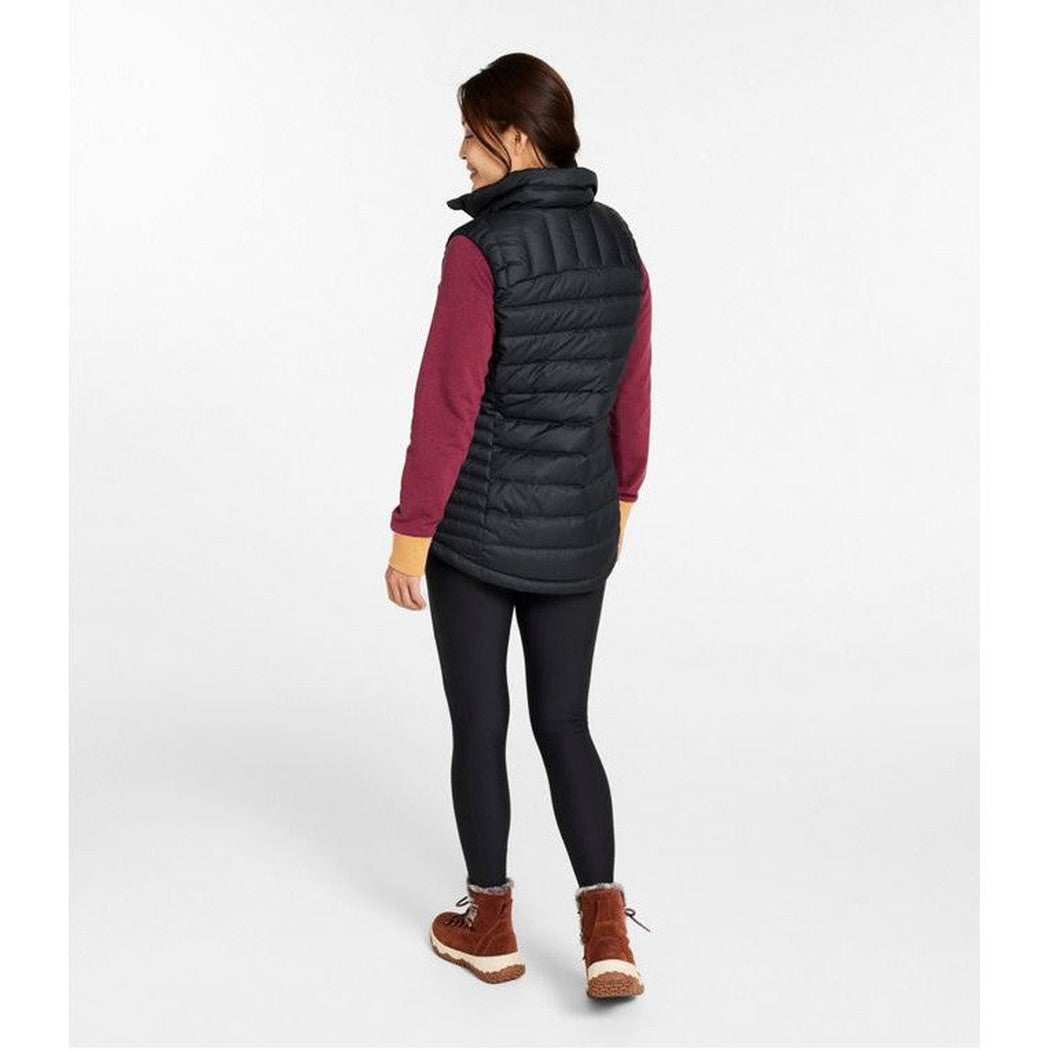 Back view of the L.L.Bean Women's Bean's Down Vest in Black on a model wearing leggings and boots against a white background.