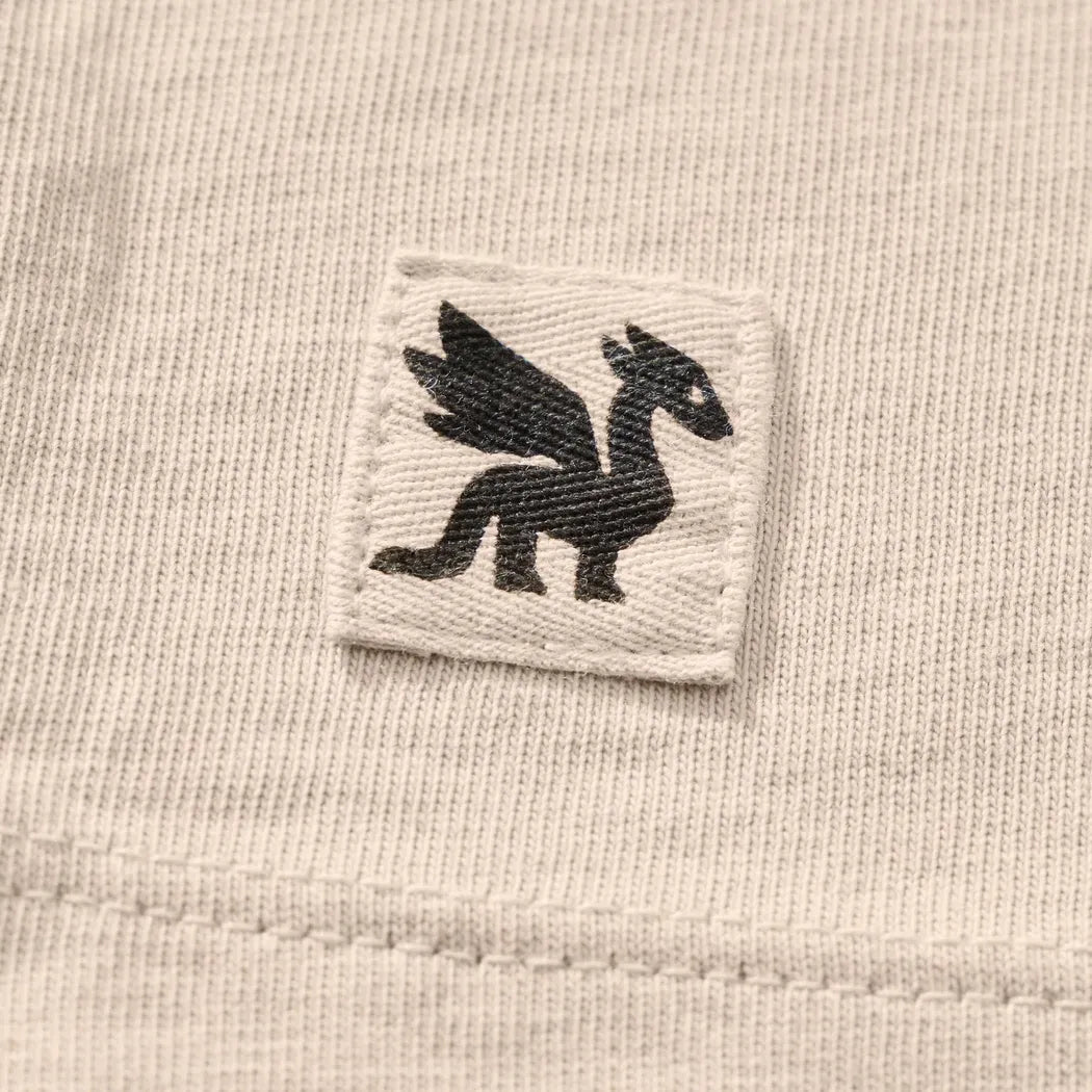 A close-up of the Life is Good Women's Collection of Mushrooms Short Sleeve Crusher Tee in Birch White showing the embroidered mushroom logo on the chest.