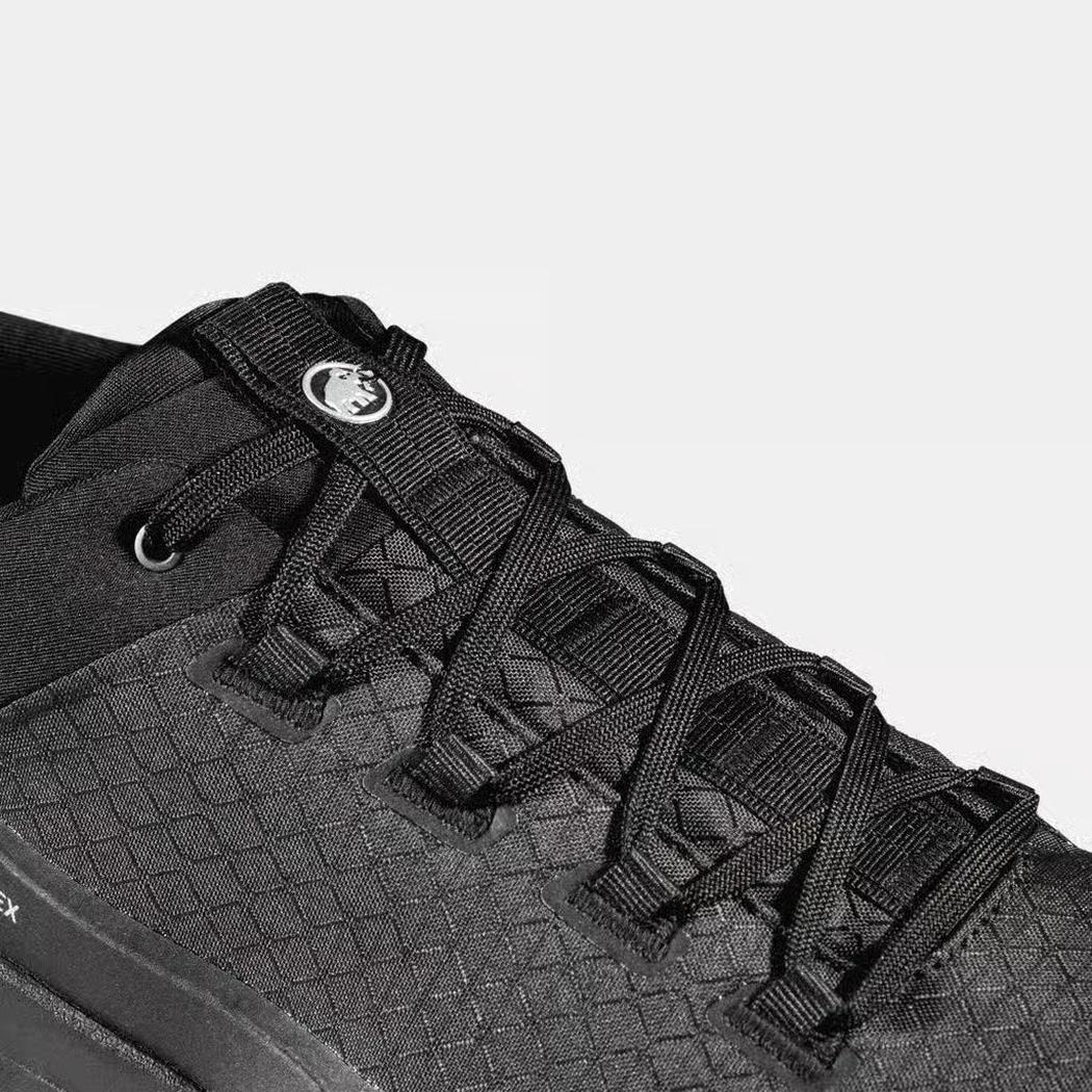 A close-up of the Mammut Sertig III Low GTX Men in Gabbro Strata, showing the lacing system and textured upper against a light background.