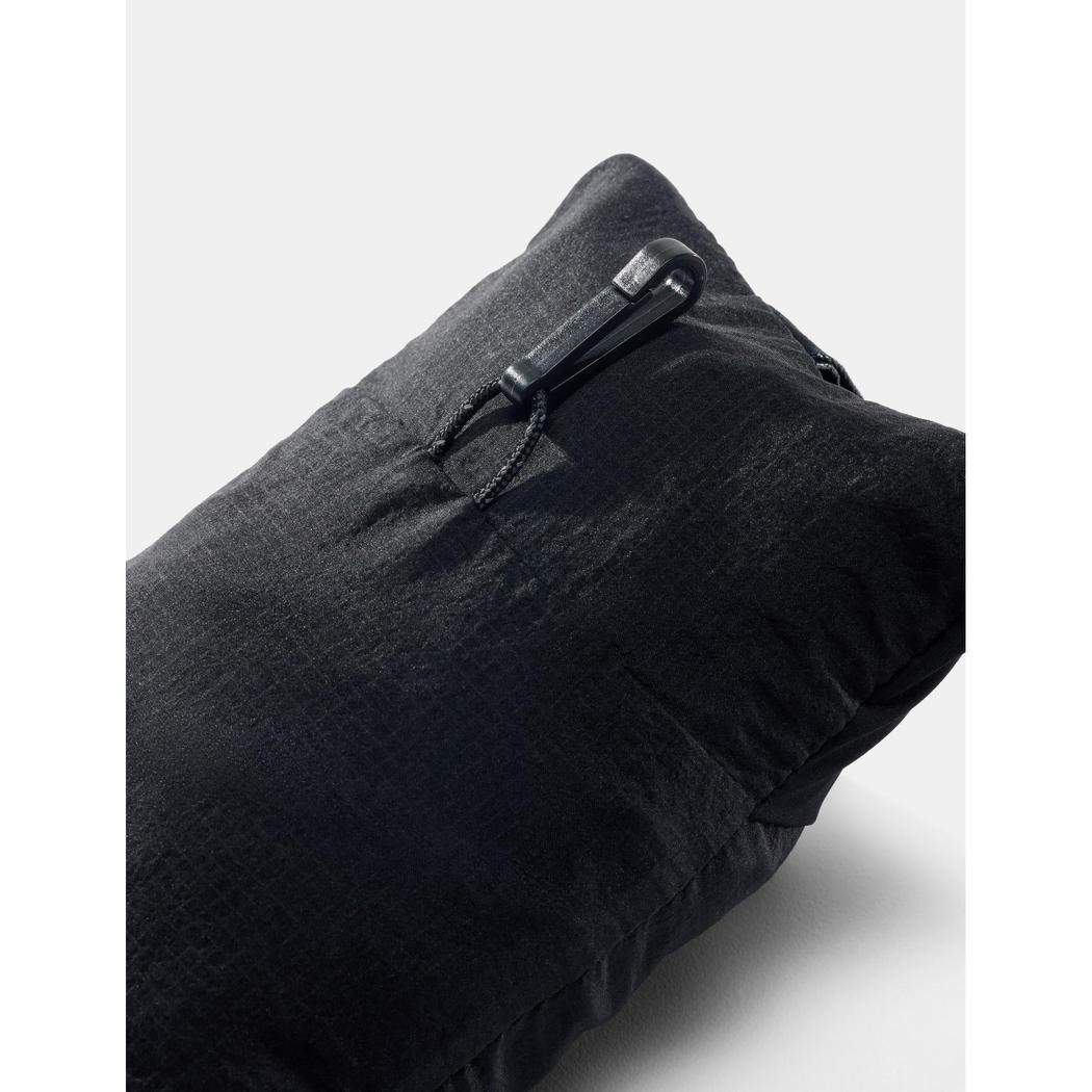 A close-up of the Matador Blackout Travel Pillow in Black showing the zipper pull and textured fabric against a light background.
