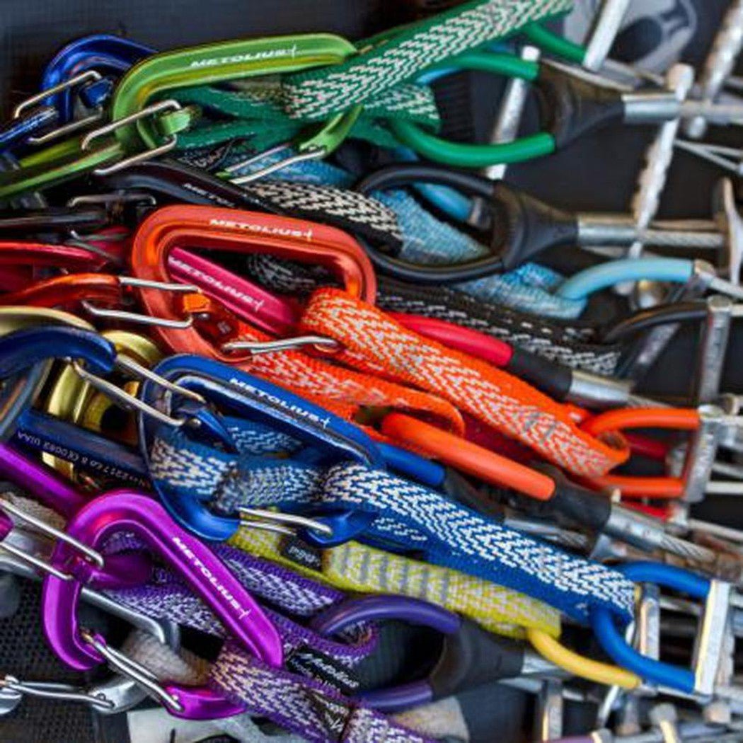 A close-up of colorful Metolius FS Mini II Jet Set 6pk carabiners stacked together, showing their metal clasps and braided ropes.