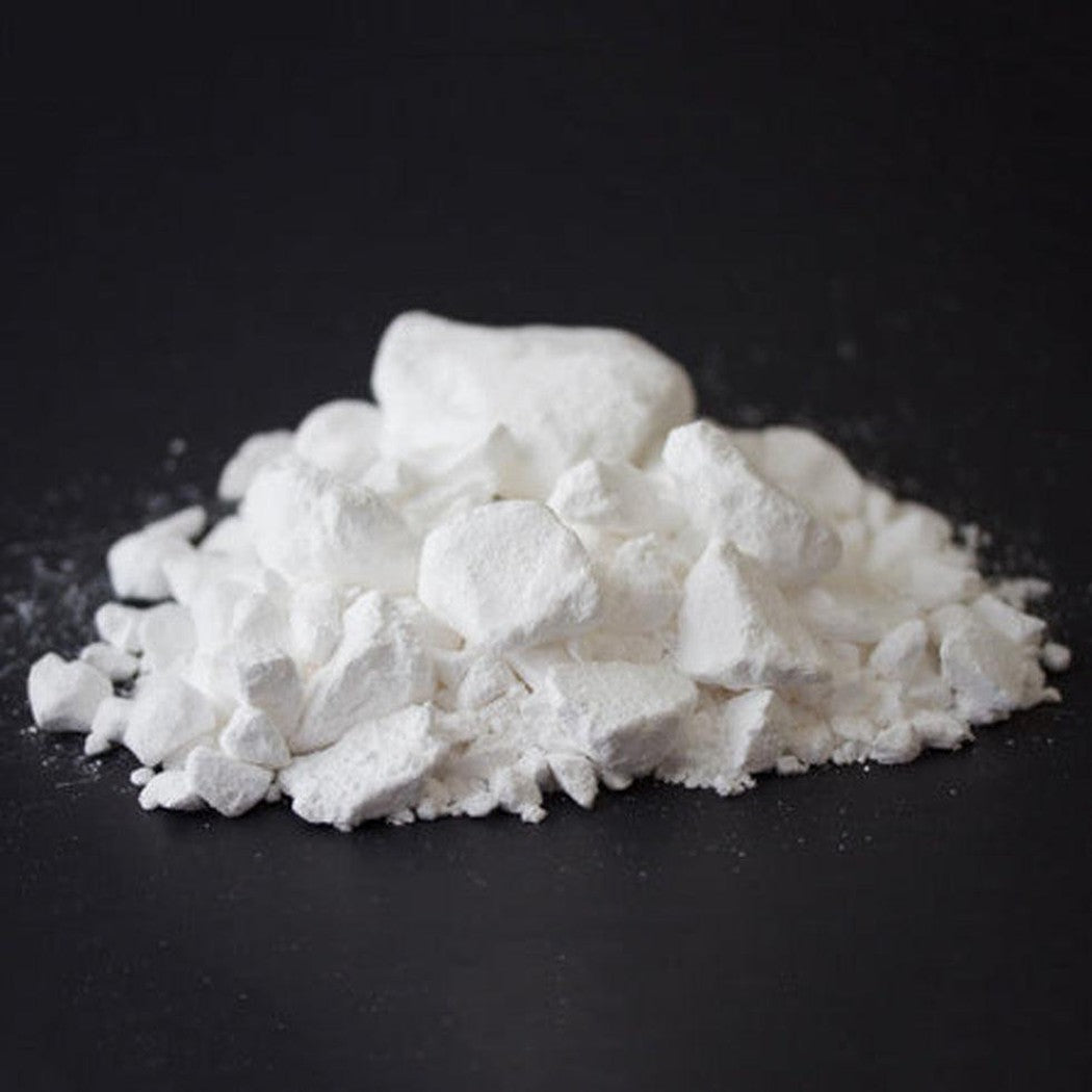 A pile of Metolius Super Chalk in 4.5 oz size on a black background.