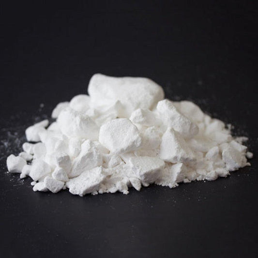 A pile of Metolius Super Chalk in 4.5 oz size on a black background.