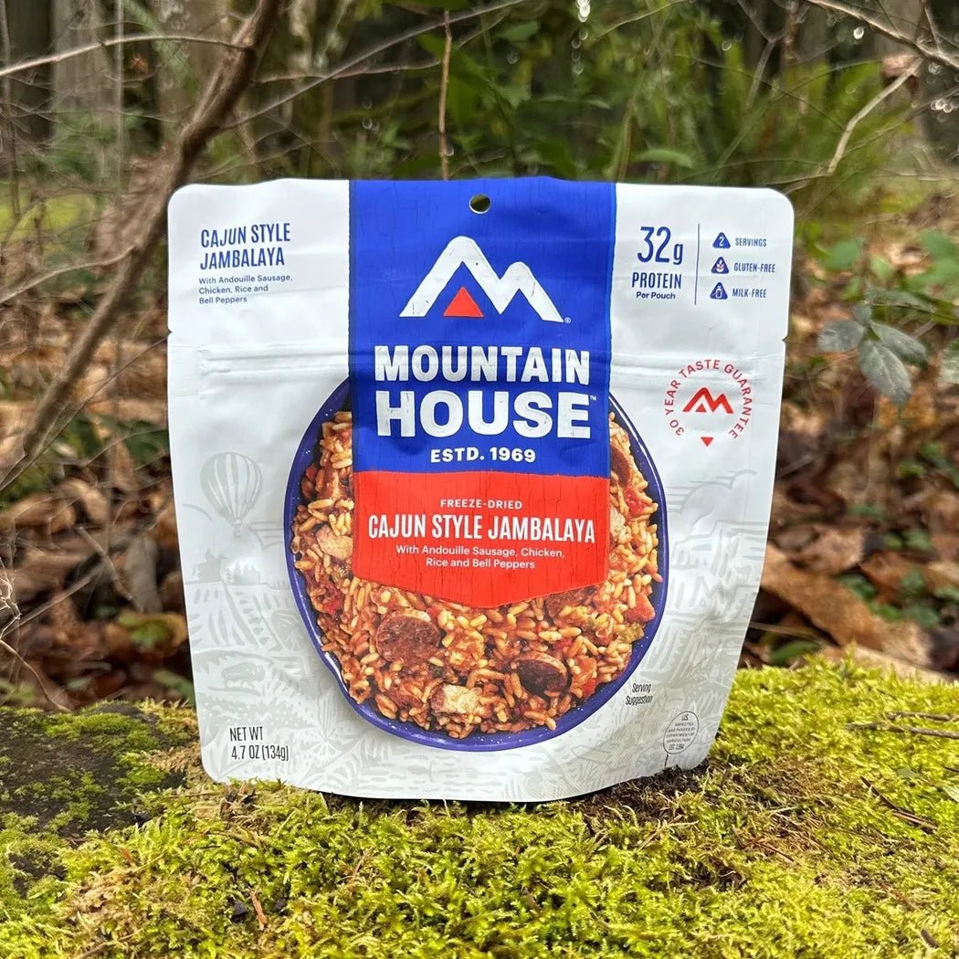 A Mountain House Cajun Style Jambalaya package sits on moss with a forest background.
