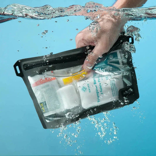 A hand holds the Nite Ize RunOff Waterproof 3-3-1 Pouch underwater with clear blue water in the background.