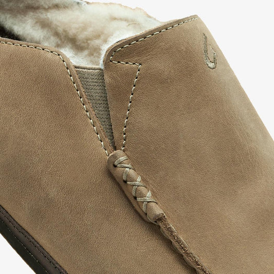 A close-up of the Olukai Men's Moloa Slipper in Clay/Dark Java showing the lace detail and shearling lining against a white background.