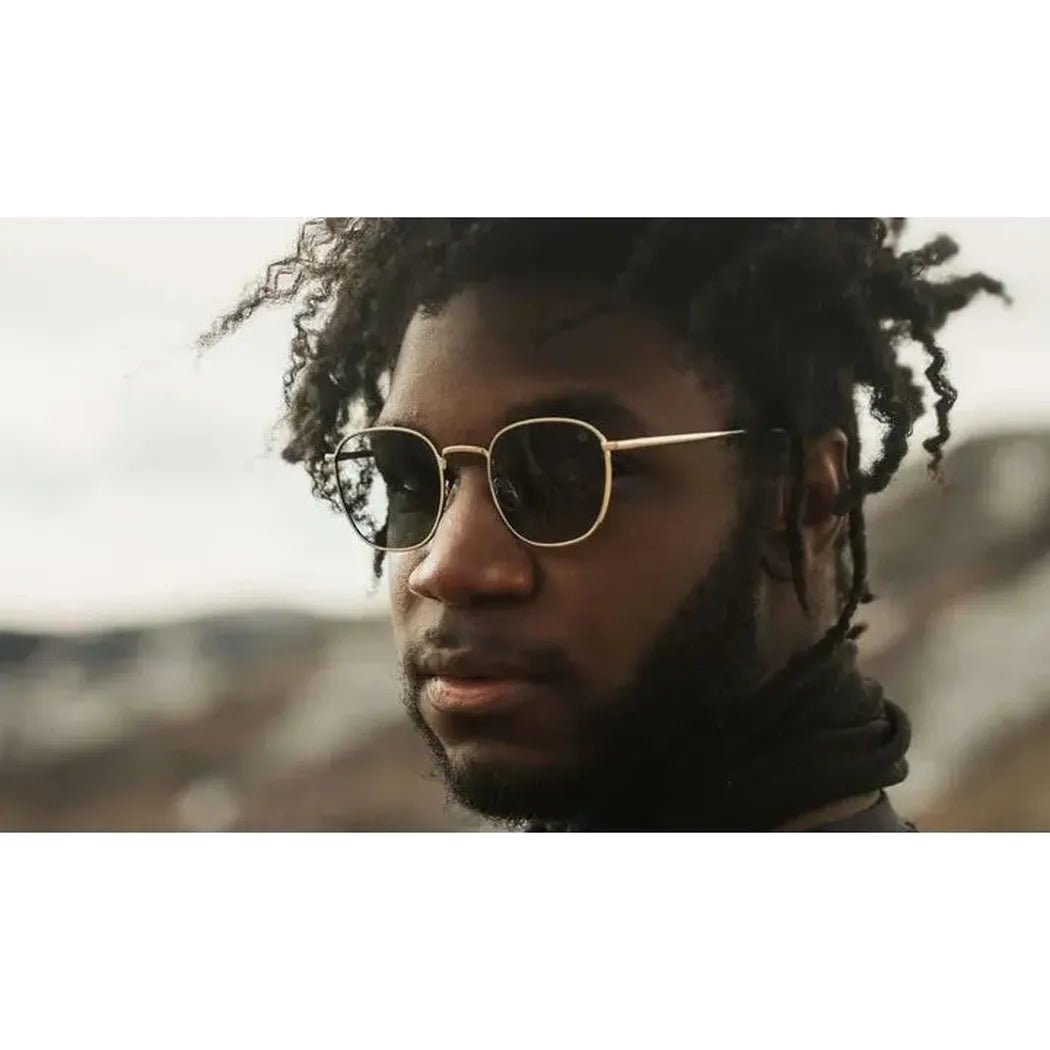 A close-up of a model wearing the Optic Nerve Townsend sunglasses with a blurred outdoor background.