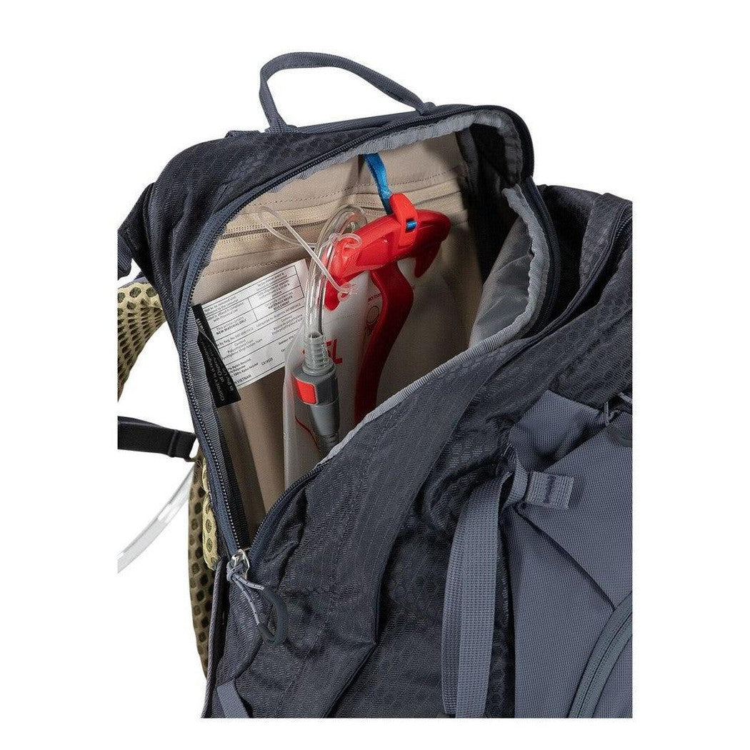 The interior of the Osprey Mira 32 backpack in Anchor Blue is open, showing a red hydration tube and a label inside.