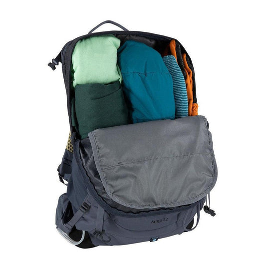 A top-down view of the Osprey Mira 32 backpack in Anchor Blue showing its organized interior with clothing items and a gray front flap against a white background.