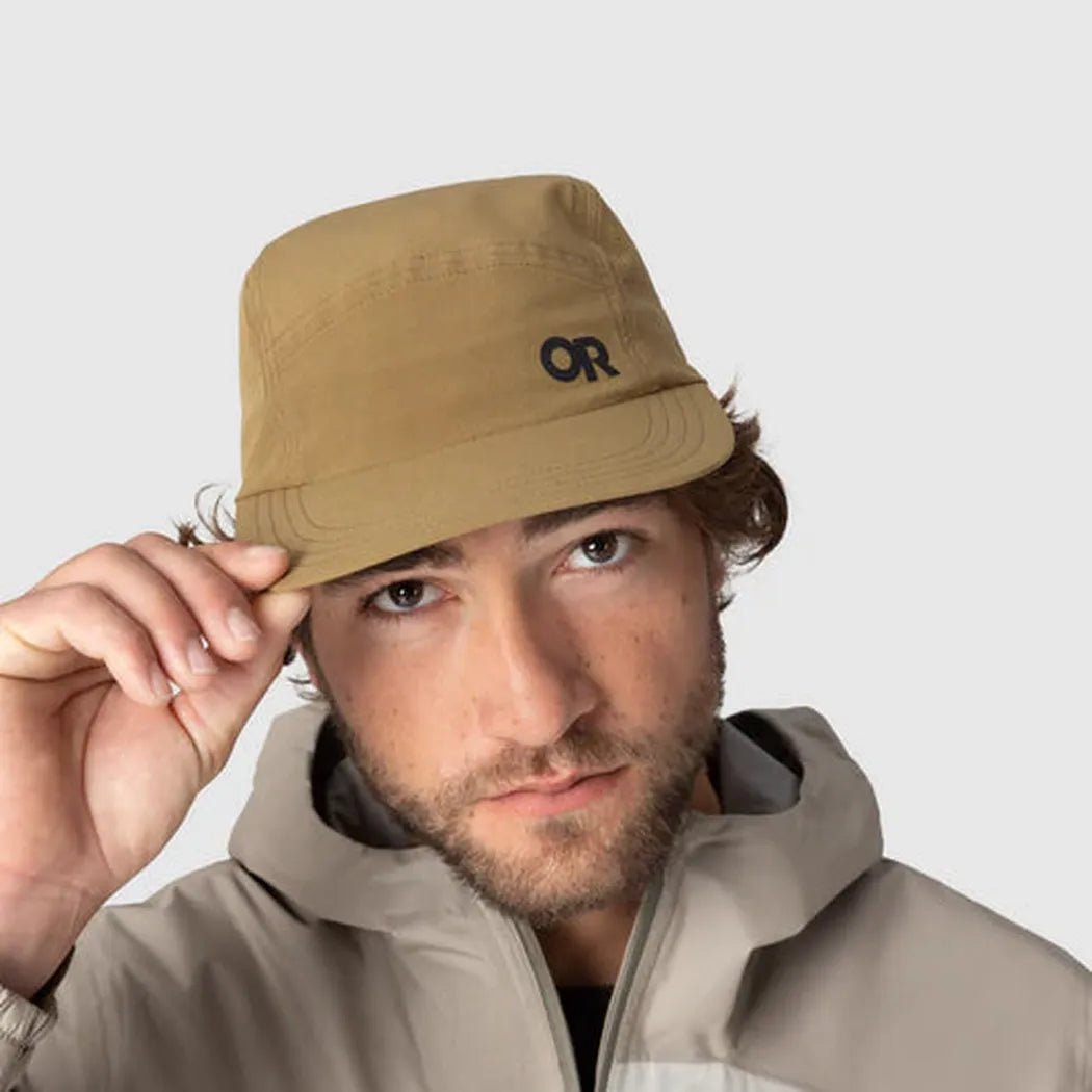A model wears the Outdoor Research Swift Lite Tech Cap in Black, holding the brim, against a plain background.
