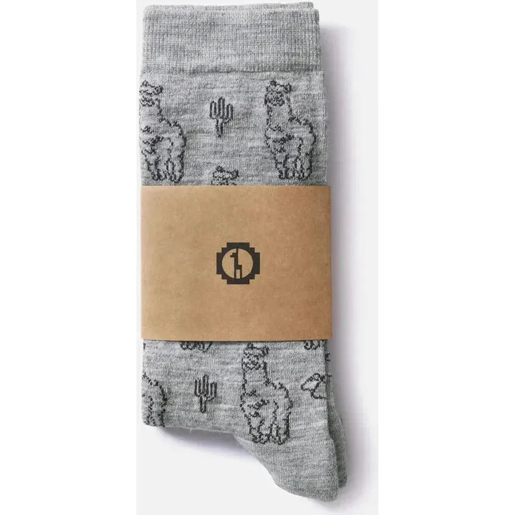 Light grey Paka Apparel Essential Sebastian Crew Socks with alpaca and cactus prints, wrapped in brown paper, photographed against a white background.