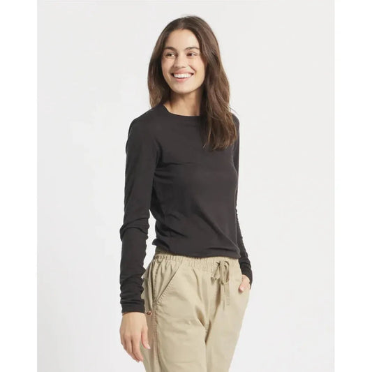 A woman wearing the Paka Apparel Women's Aire Long Sleeve in Black stands against a plain white background.