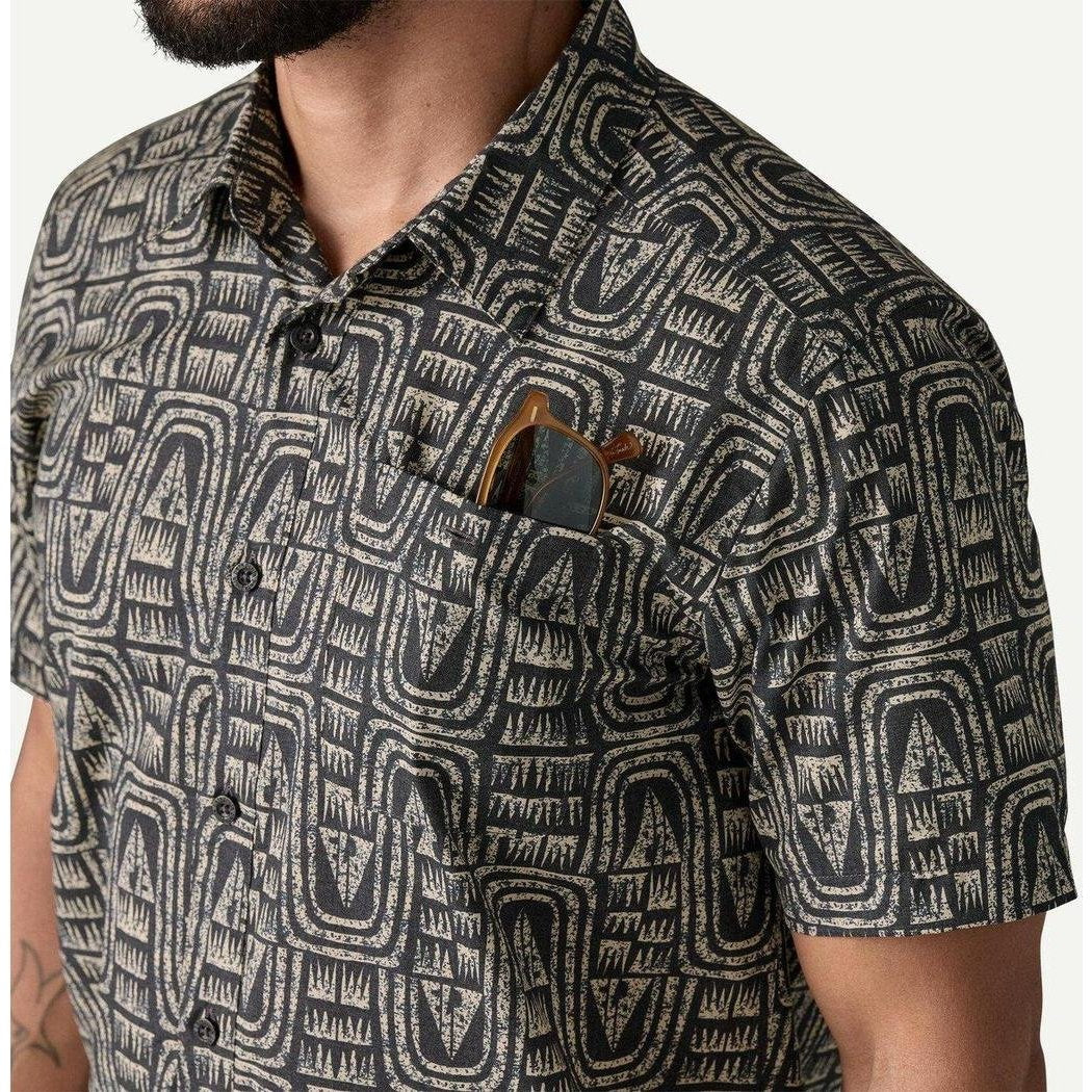 A close-up of a man wearing the Patagonia Men's Go To Shirt in Flow: Sunken Blue, showing the pocket with sunglasses against a plain background.