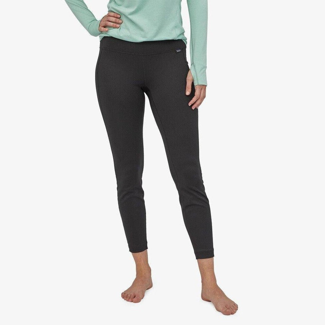 A front view of the Patagonia Women's Cap Midweight Bottoms in Black on a model against a white background.