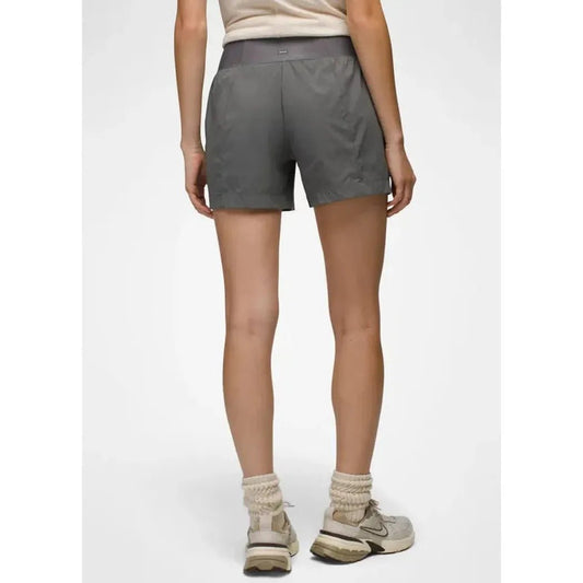 Back view of the Prana Women's Koen Short in Grape Leaf on a model wearing light-colored sneakers against a plain white background.
