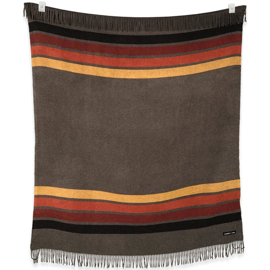 A charcoal and desert striped blanket from the Sackcloth & Ashes Camp Collection hangs on a white background.