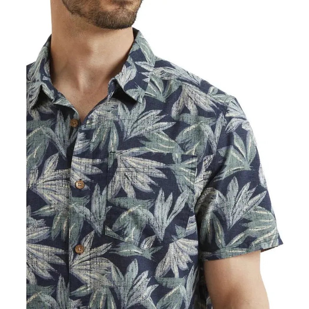 A close-up of the Sherpa Adventure Gear Men's Havai Short Sleeve Shirt in Rathee Blue, showing the front buttons and leaf pattern against a white background.